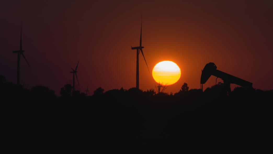 Wind turbines with oil jack at sunset