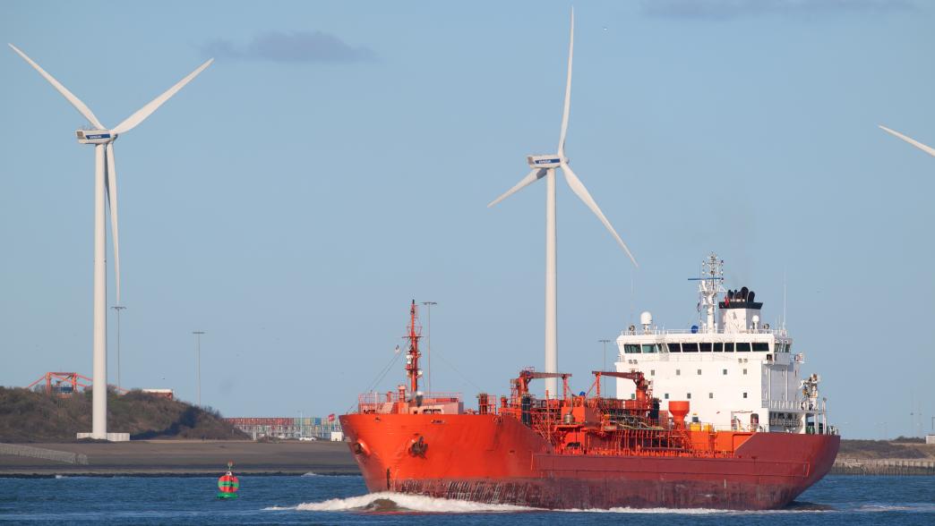 Red oil tanker in harbor with wind mills