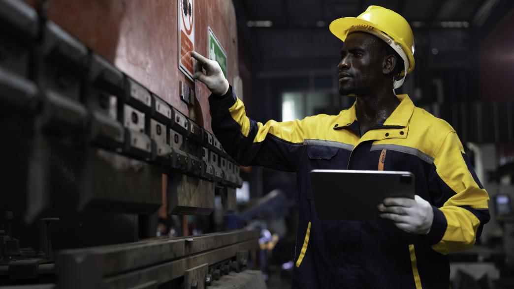 Portrait of male engineer at work inspecting quality of industrial machinery