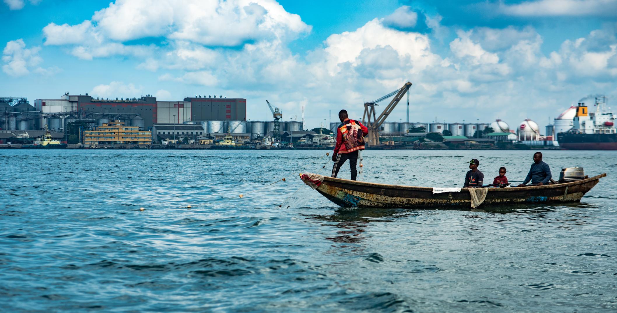 Men on a boat fishing along Lagos lagoon