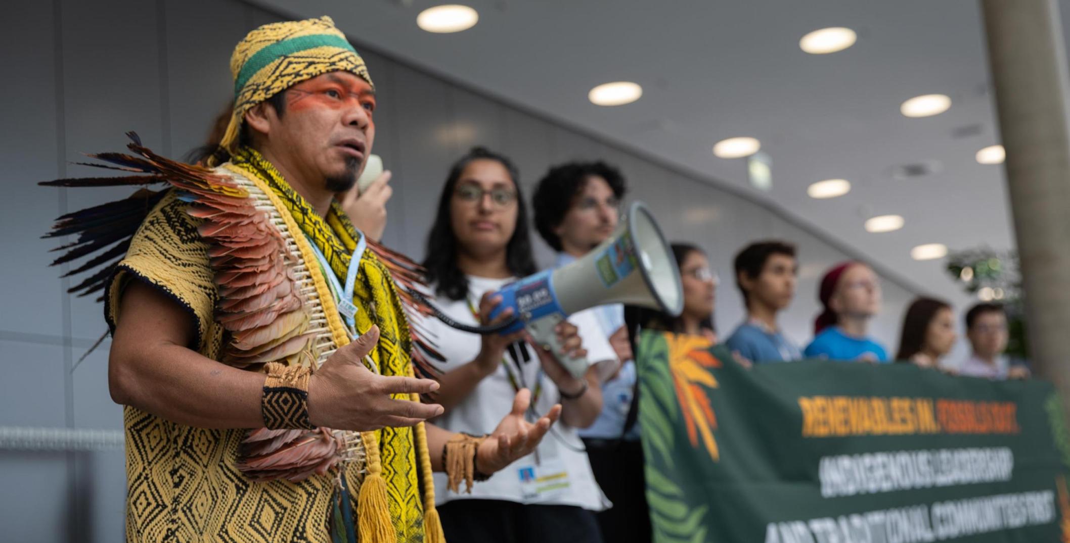 Indigenous People holding a banner and protesting at Bonn Climate Conference 2025