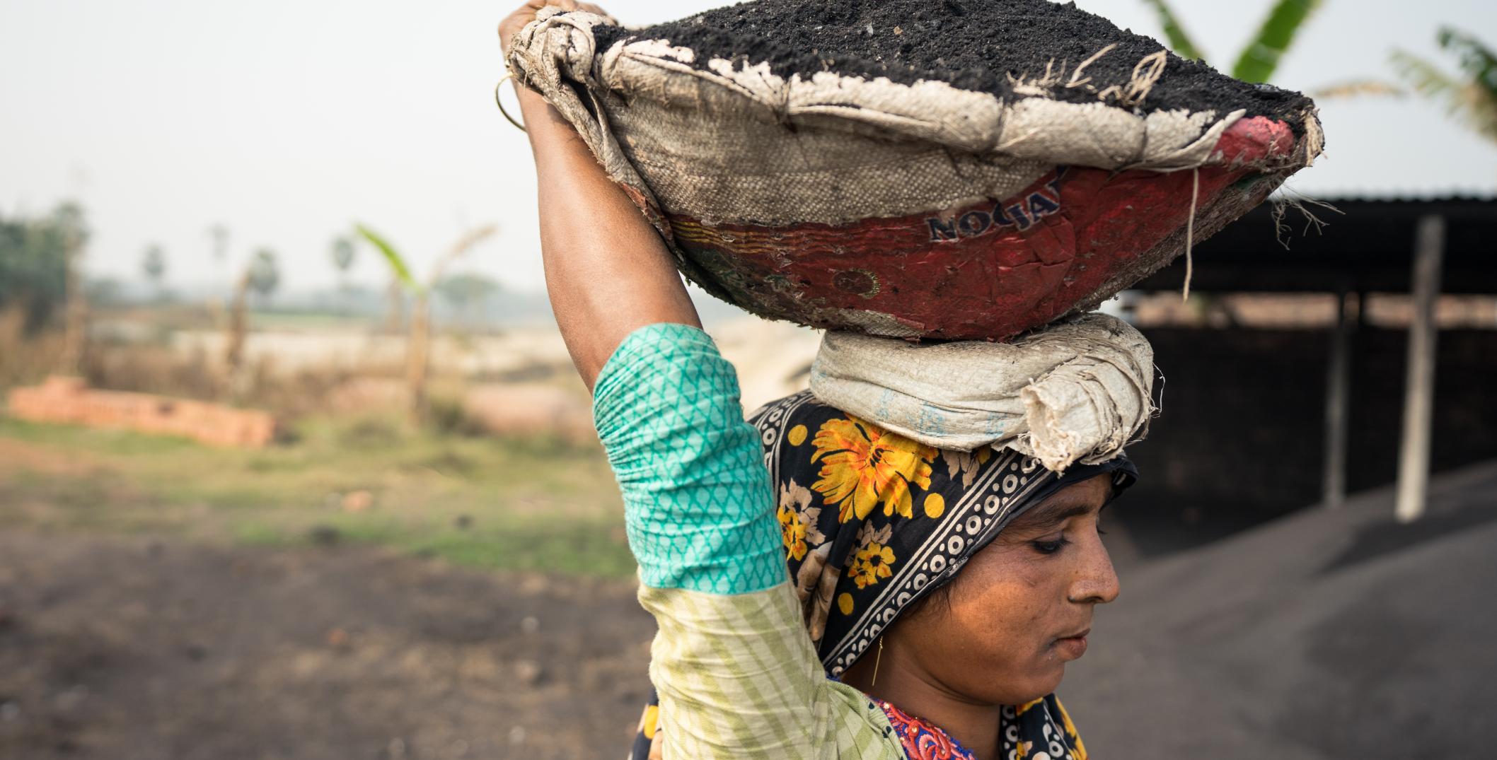 Woman working carrying coal on her head
