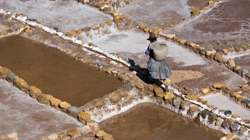 Local woman working on the Maras Salt Pans on a mountainside above Urubamba in Peru