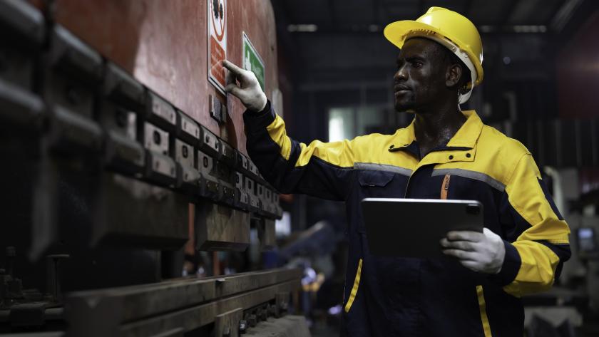 Portrait of male engineer at work inspecting quality of industrial machinery