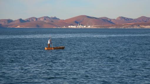 A man paddles small boat in Cortez sea, Mexico