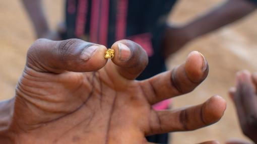 Ghanaian miner holding a small nugget of gold