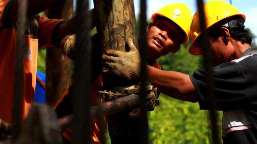 Workers drill a new well as part of crude oil mining in Indonesia