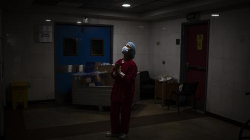 Lebanese nurse in a mask in a dark hospital room, Beirut, Lebanon
