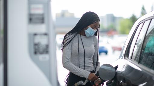 African American woman at gas station wearing mask -