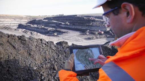 Worker sing digital tablet at the coal mine site, elevated view
