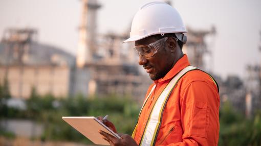 Engineer using tablet near oil refinery