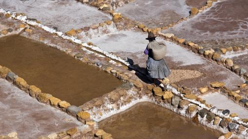 Local woman working on the Maras Salt Pans on a mountainside above Urubamba in Peru