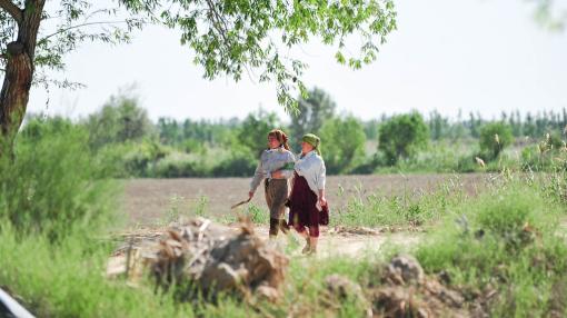 Two women walking near a forest