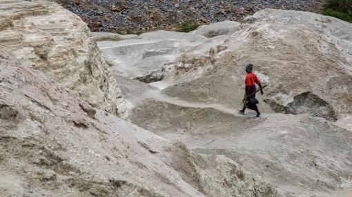 A woman walks on top of a hill formed from the old mining activities' residue