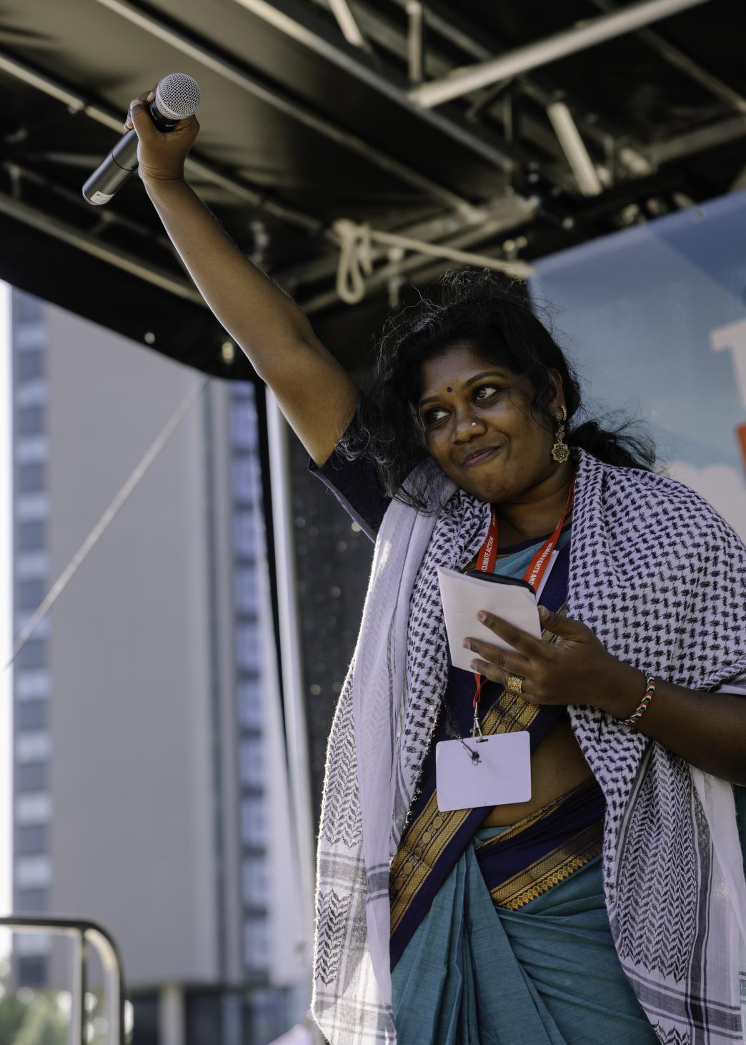 Woman giving speech holding arm aloft