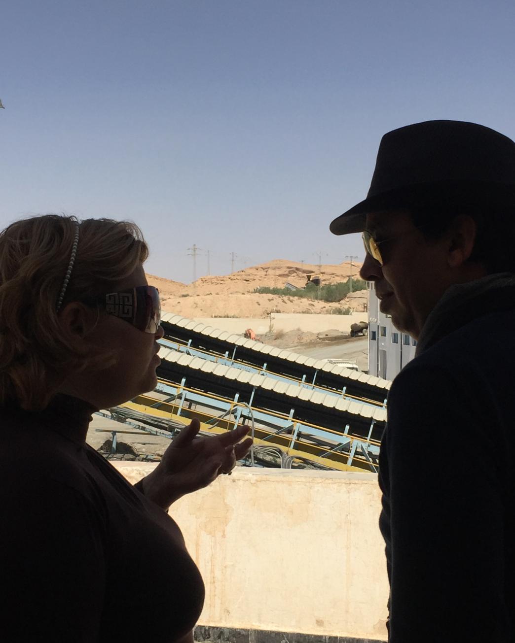 A woman and a man talking near a mining site