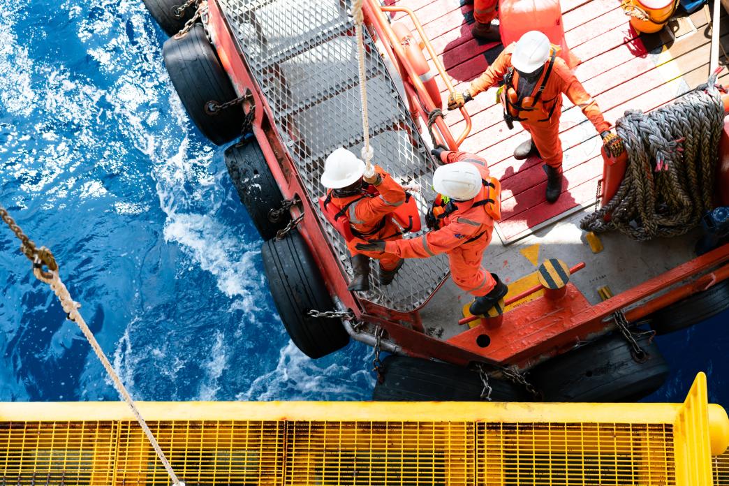 Offshore oil and gas platform during crew boat transfer worker to the platform during sunset time